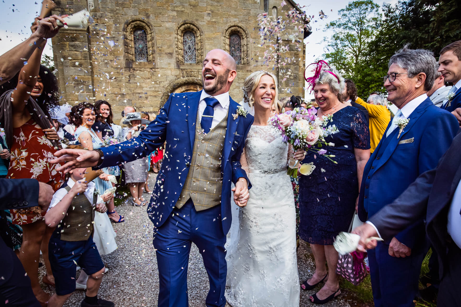 bride and groom being showered with confetti outside a Lake District church