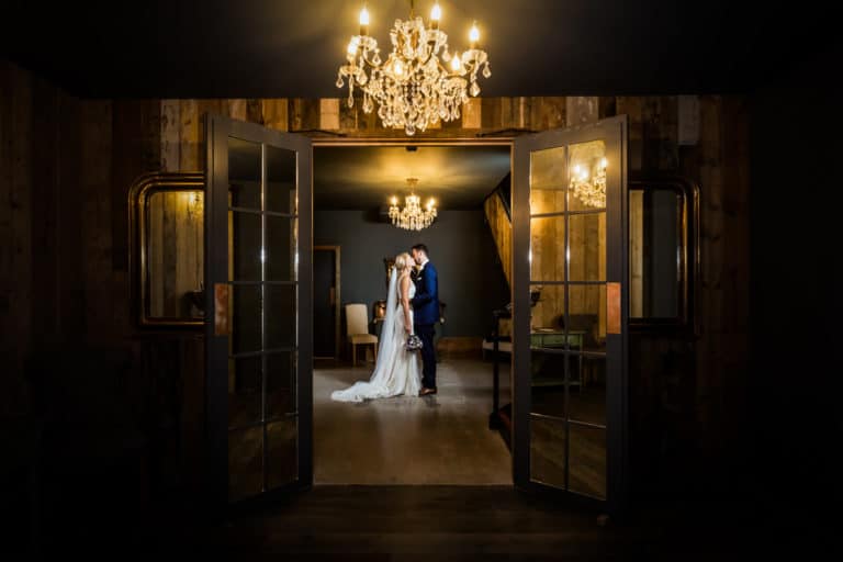 wedding couple kissing under chandelier at Wharfedale Grange