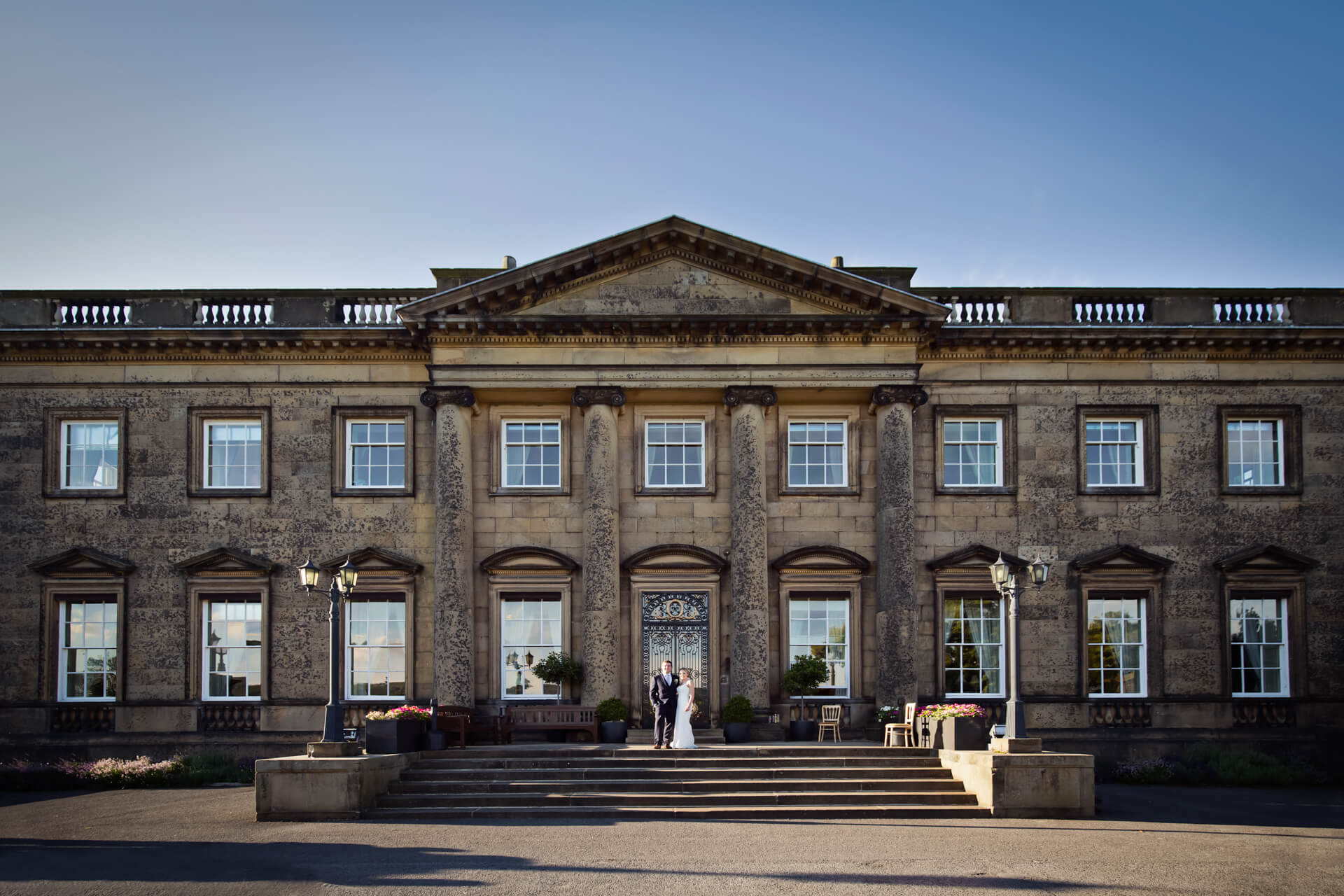 Bride & groom on the steps of Denton Hall