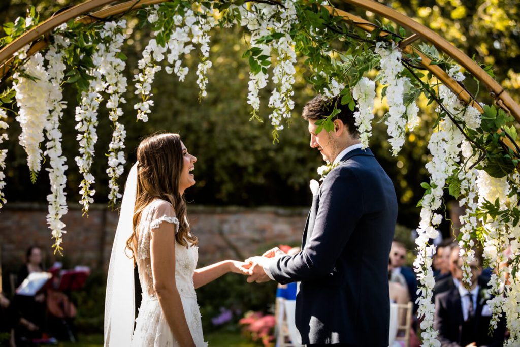 Bride and groom saying their vows in the gardens at Saltmarshe Hall