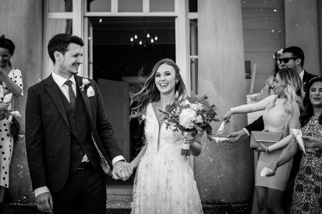groom smiling at the bride after the confetti