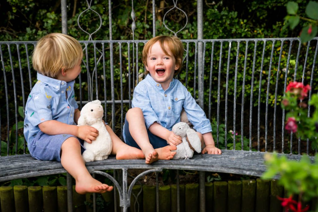 two small boys sitting together and laughing