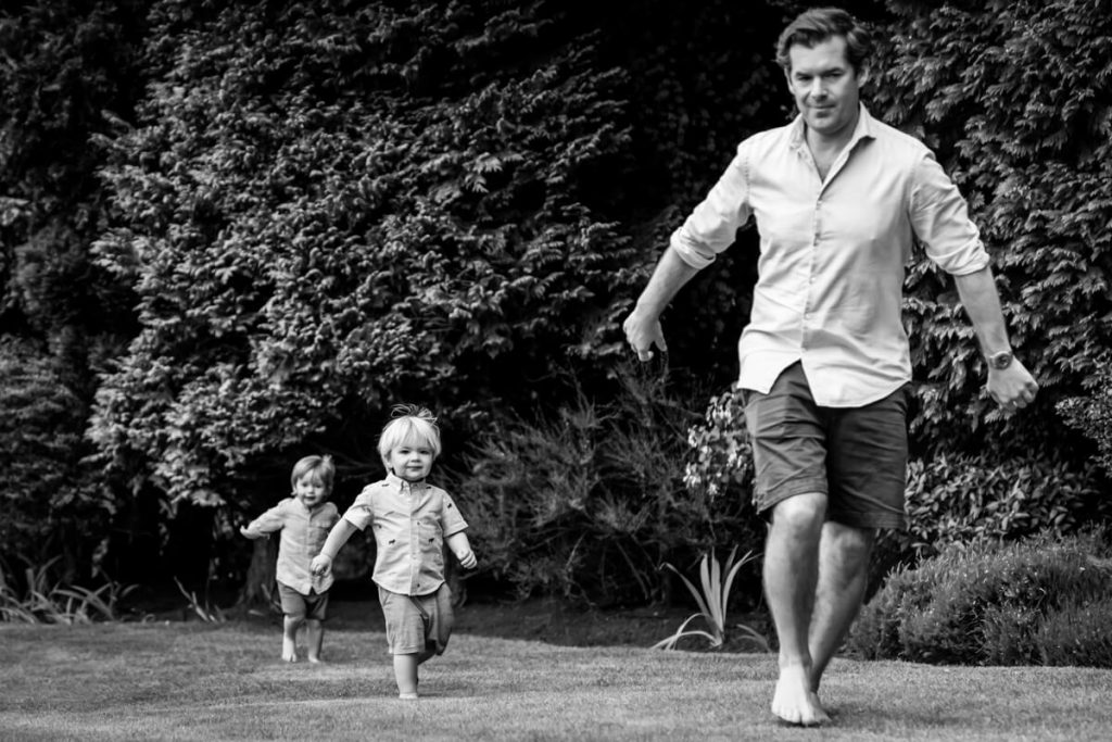 two little boys running after their father