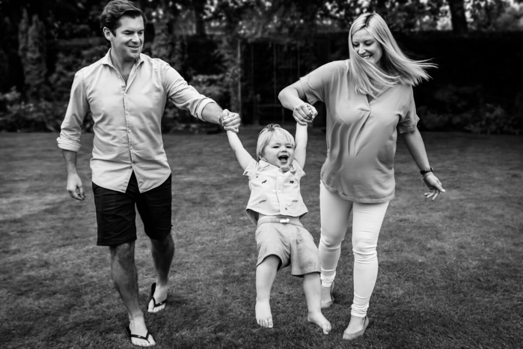 parents swinging their boy up in the air