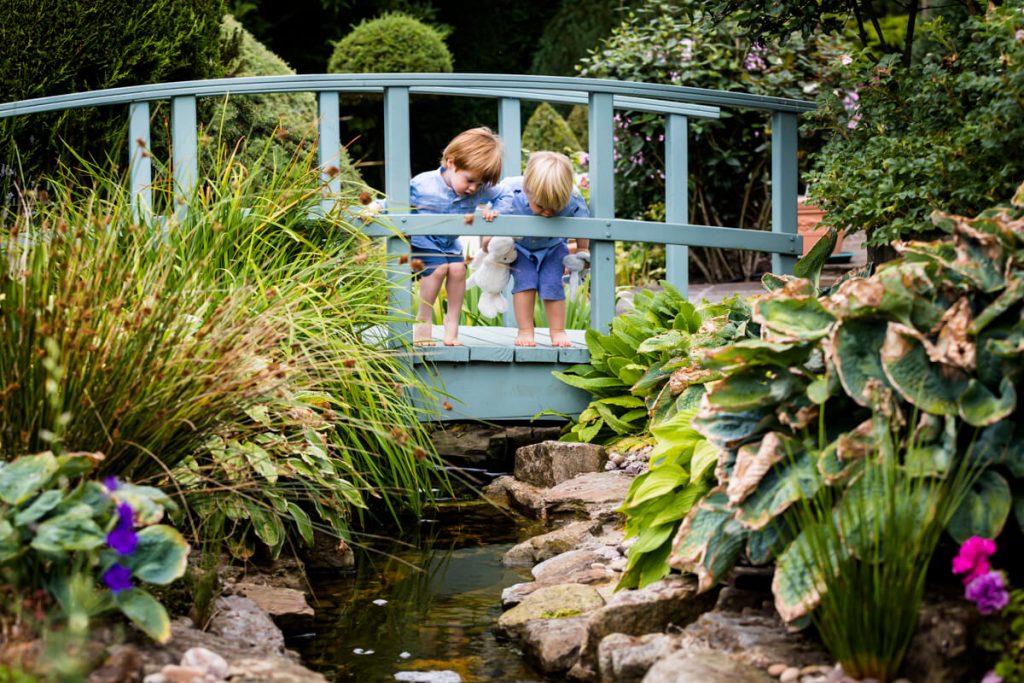 two little boys looking over a bridge down at a river