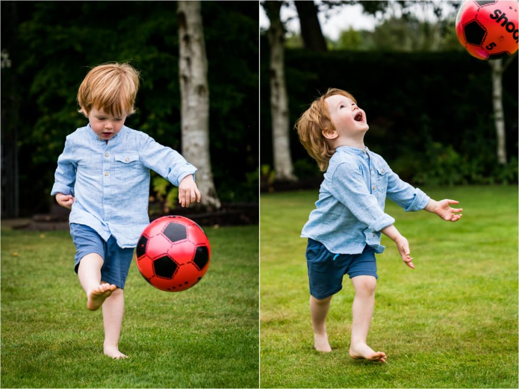 Little boy paying football in a family garden in yorkshire