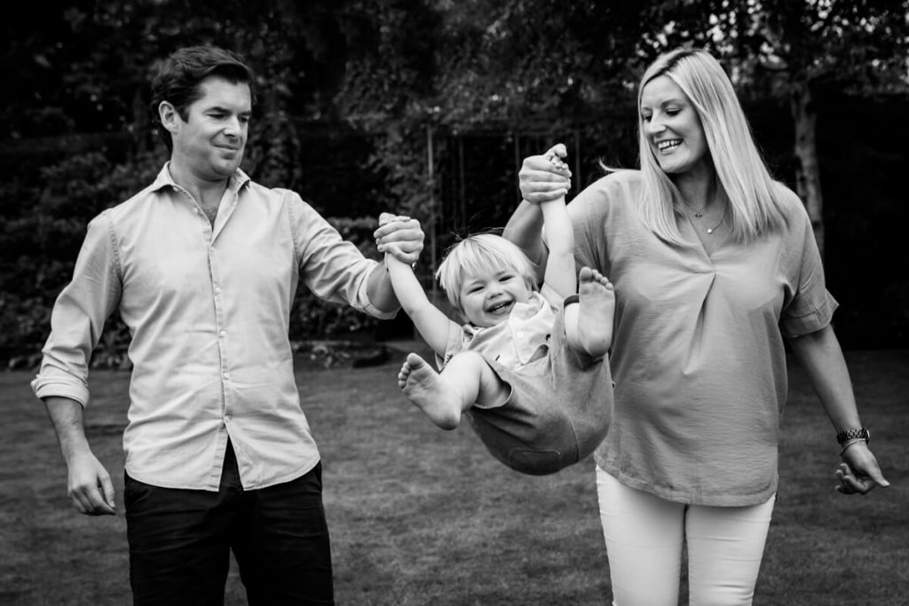 mum and dad swinging their little boy