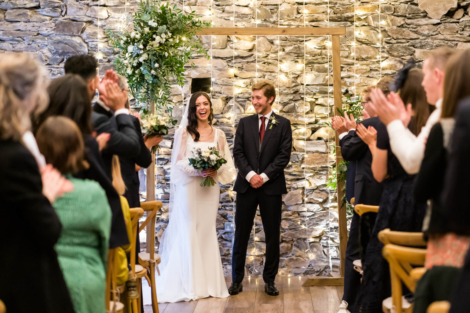 the wedding couple are cheered by their family and friends