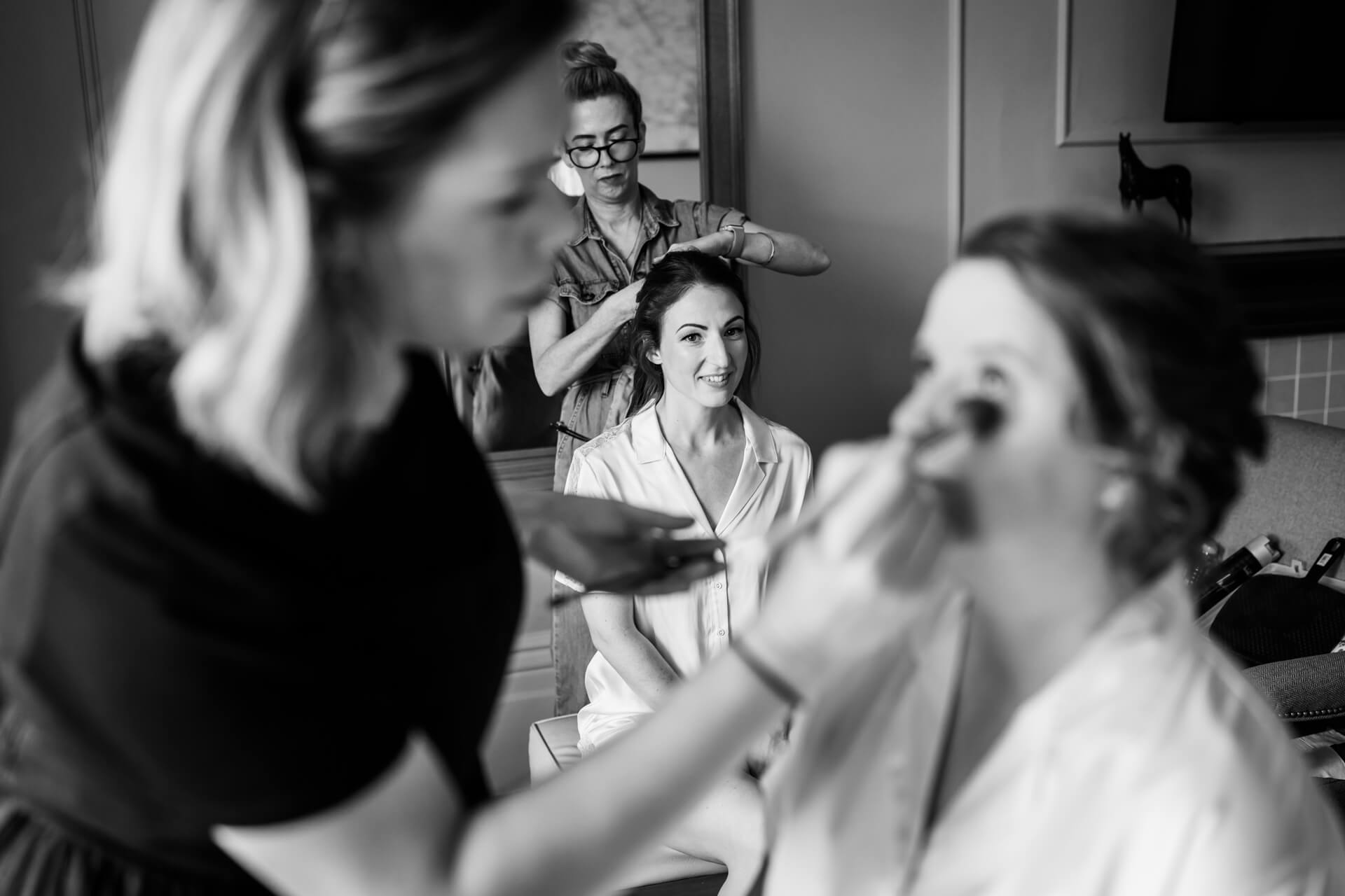bride and bridesmaids having hair and makeup done