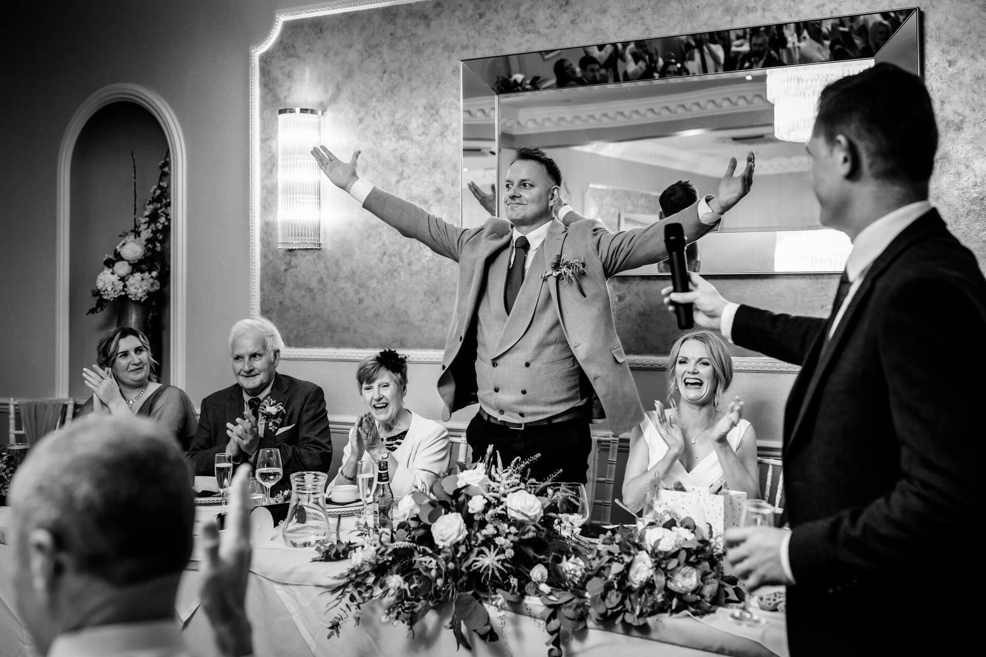 groom standing to applause from guests during the speeches