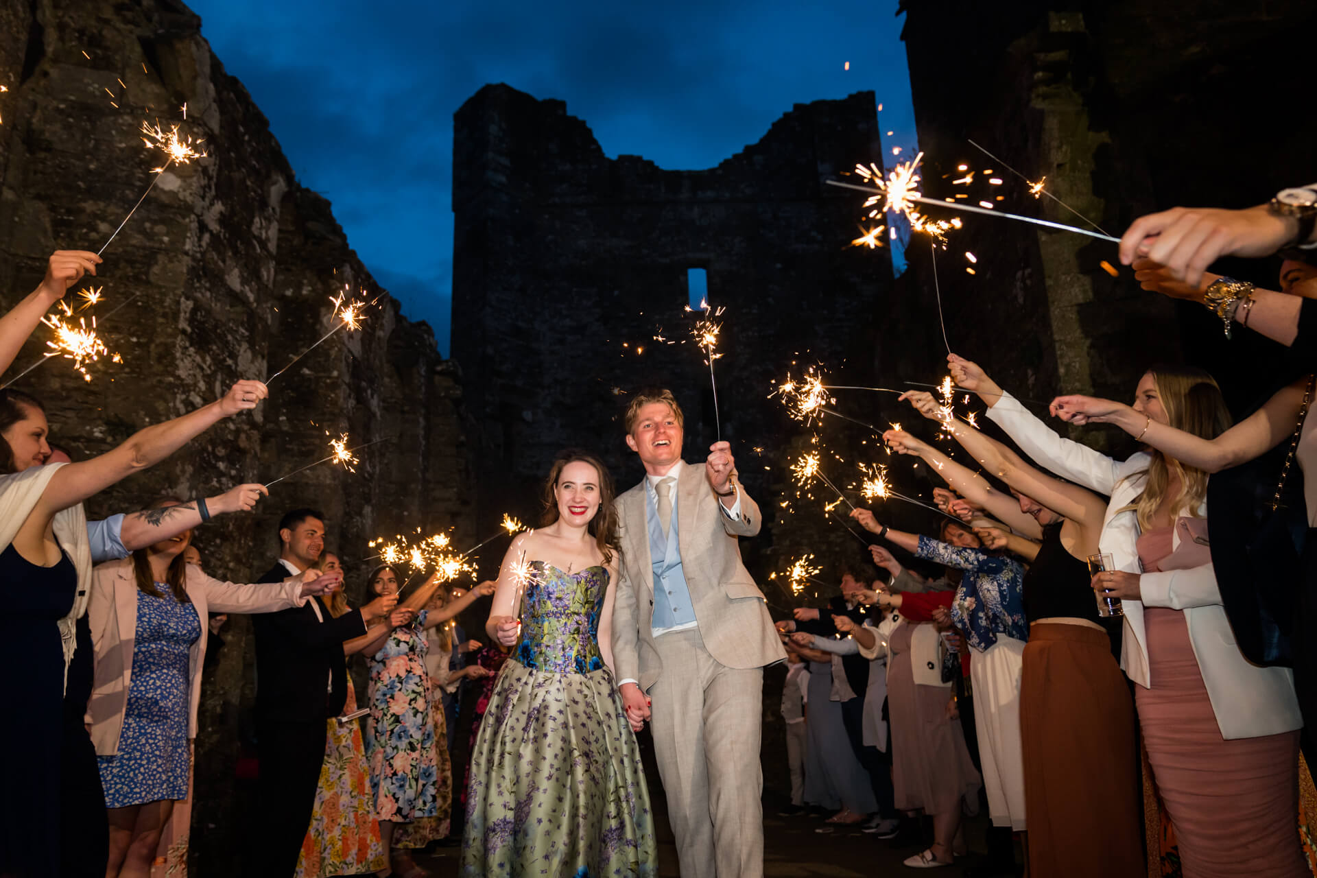 bride and groom walk a sparkler tunnel on the top of Bolton Castle