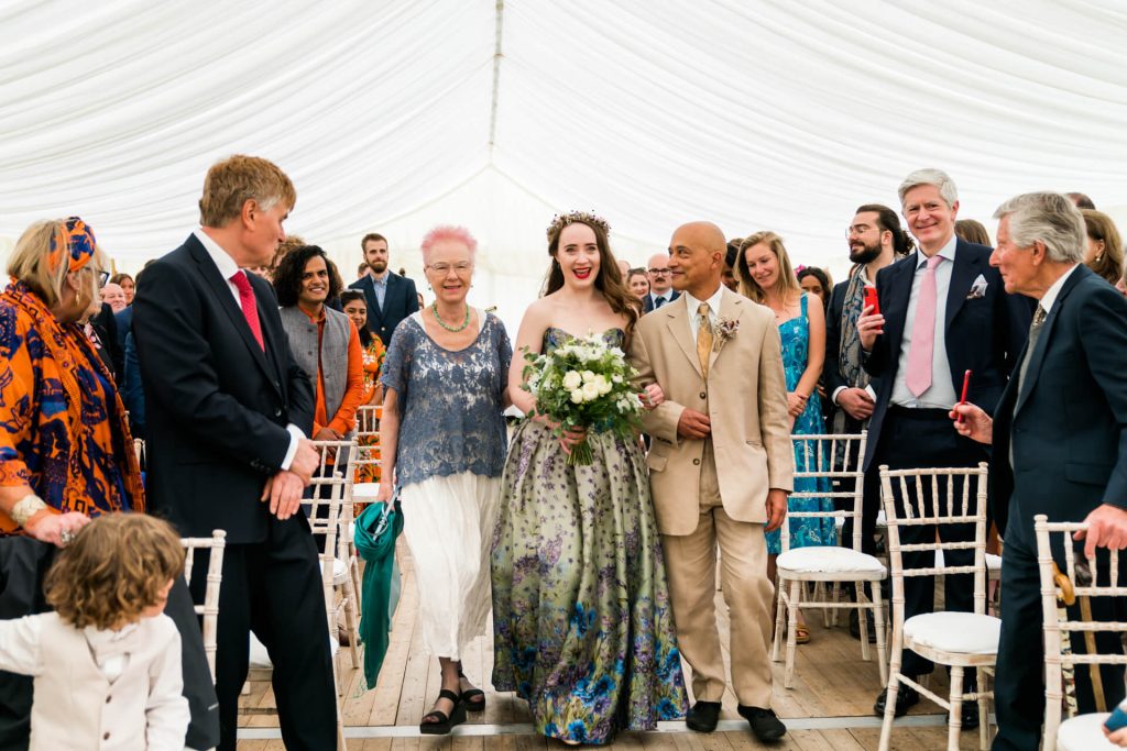 bride and her Mum and Dad walking down the aisle