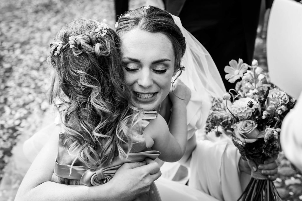 bride hugging a flower girl