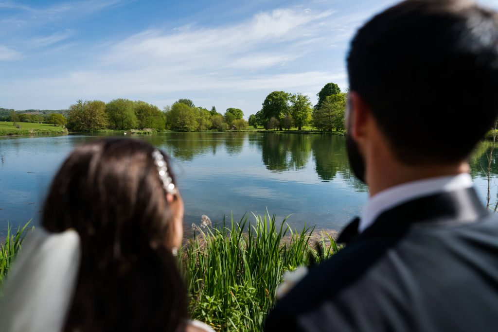 bride and groom looking at a lake