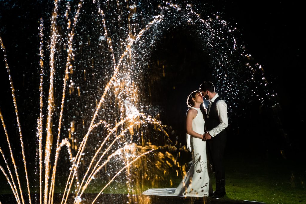 wedding couple under the fountain at the orangery at Settrington