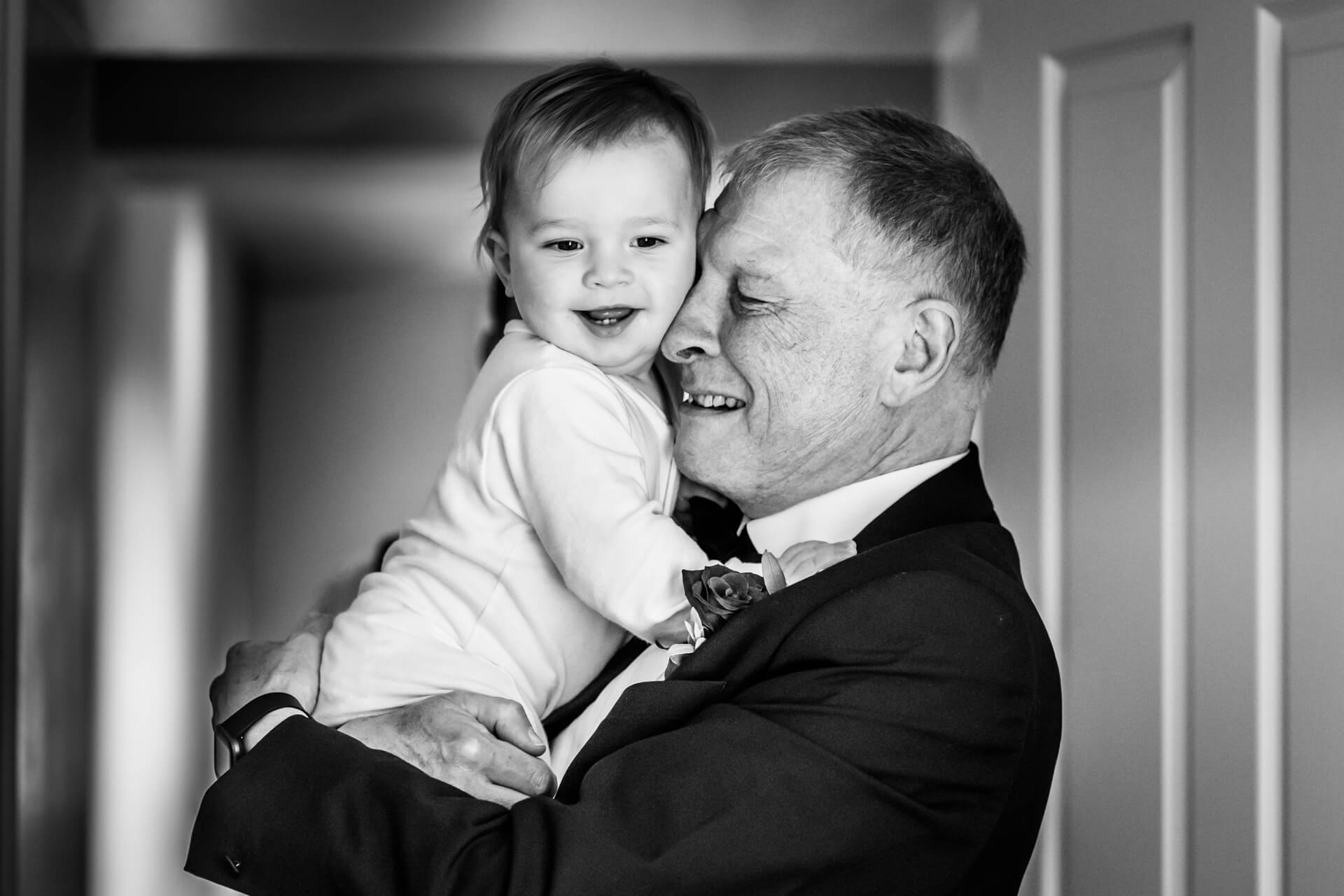 grandad hugging his daughter's baby boy
