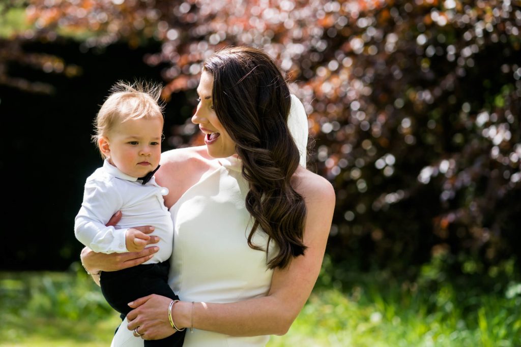 bride holding her baby boy and laughing