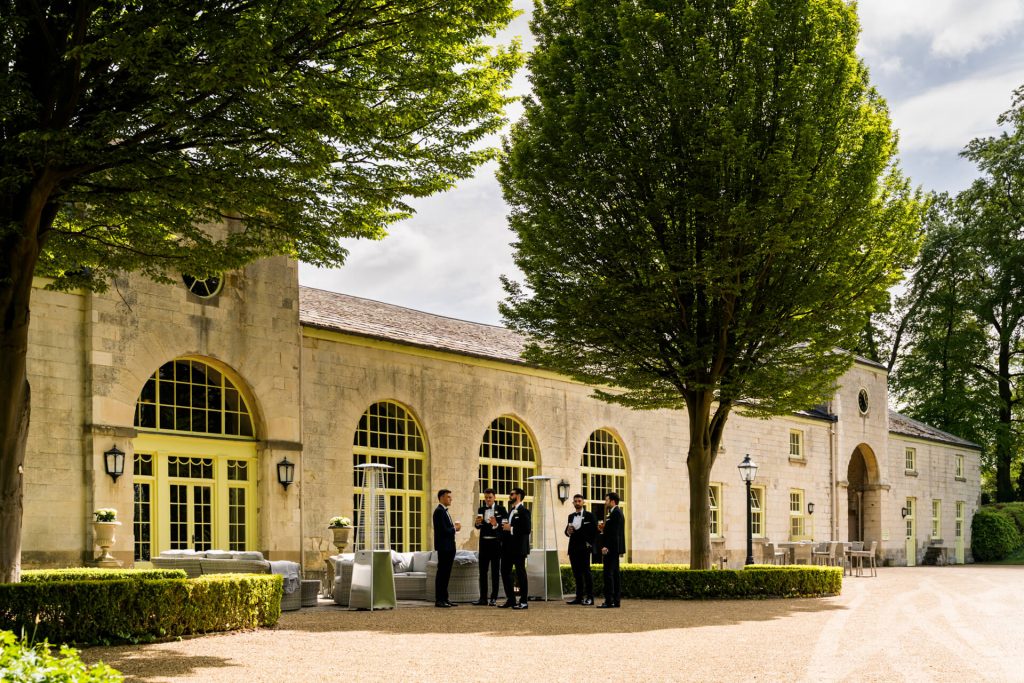 groomsmen standing outside the the orangery at Settrington