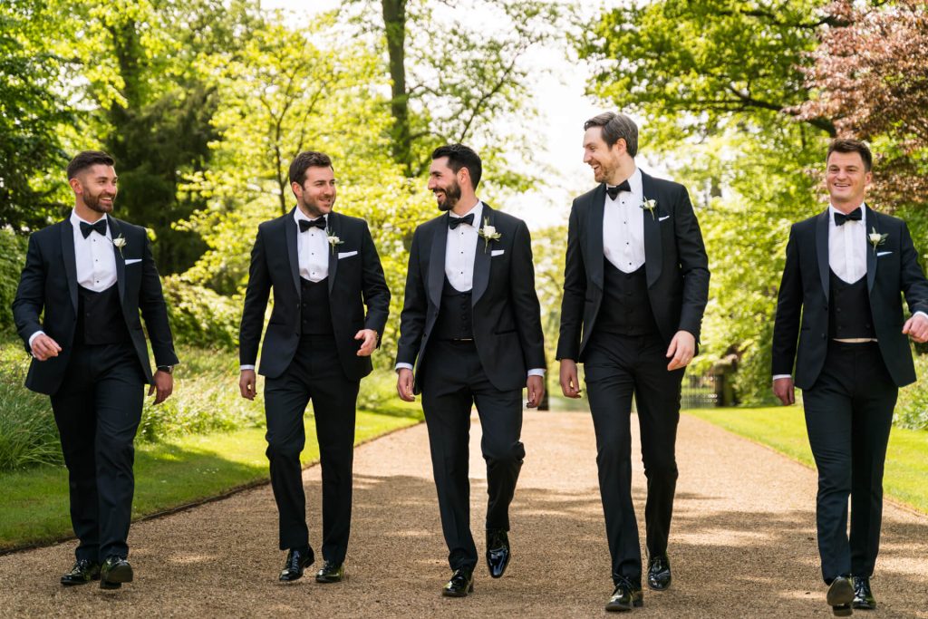 groomsmen walking down the path outside the orangery at Settrington