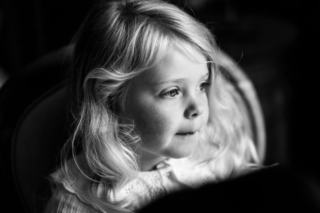 flower girl looking out of a window