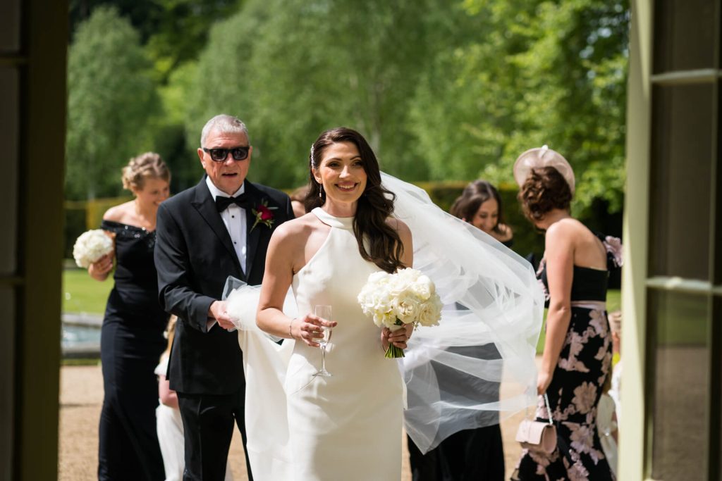 bride enters the ceremony room smiling