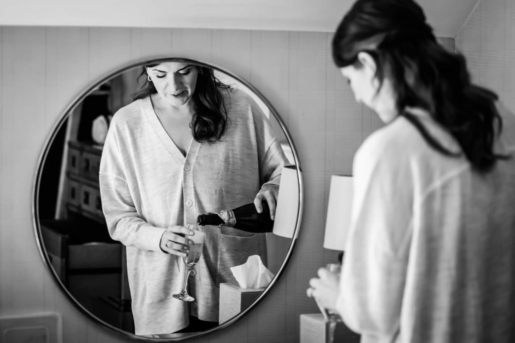 mirror reflection of a bridesmaid pouring wine