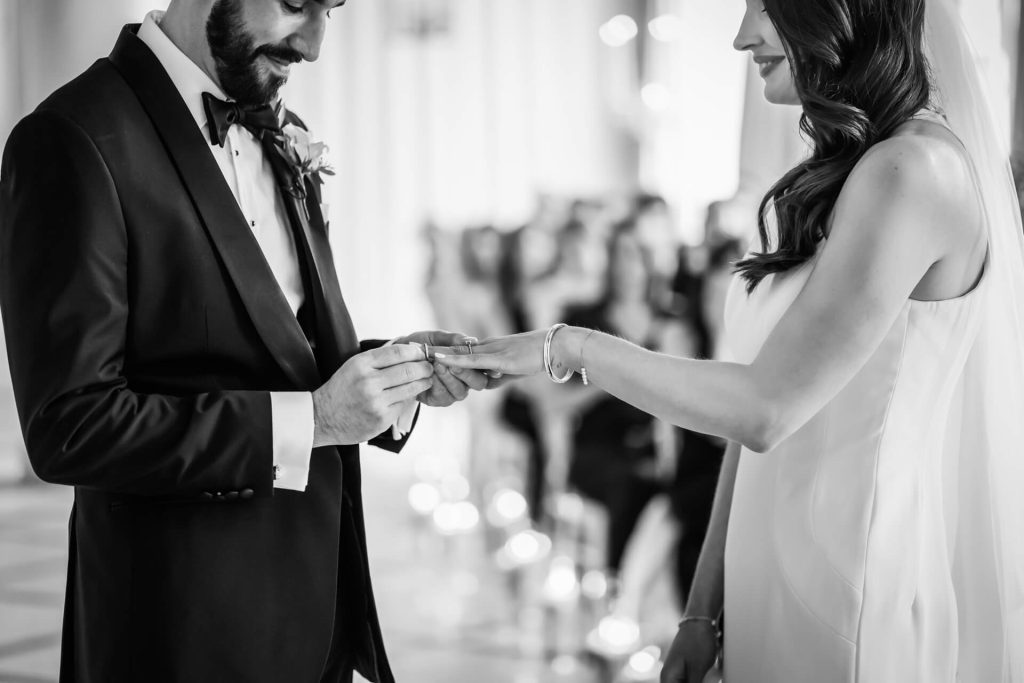 groom putting the ring on the bride's hand