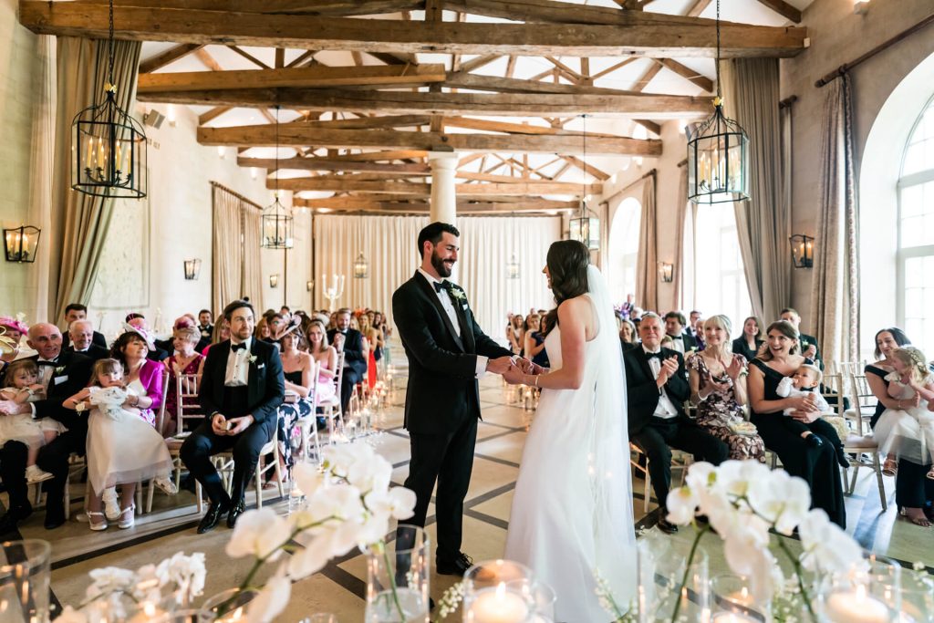 wedding couple holding hands during the ceremony at the orangery at Settrington