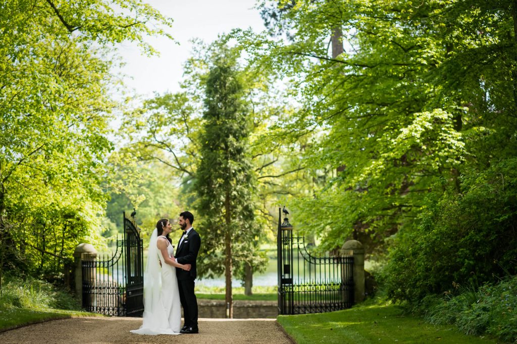 bride and groom standing in front of the gate at the orangery at Settrington