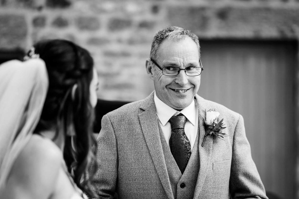 brides father smiles at her