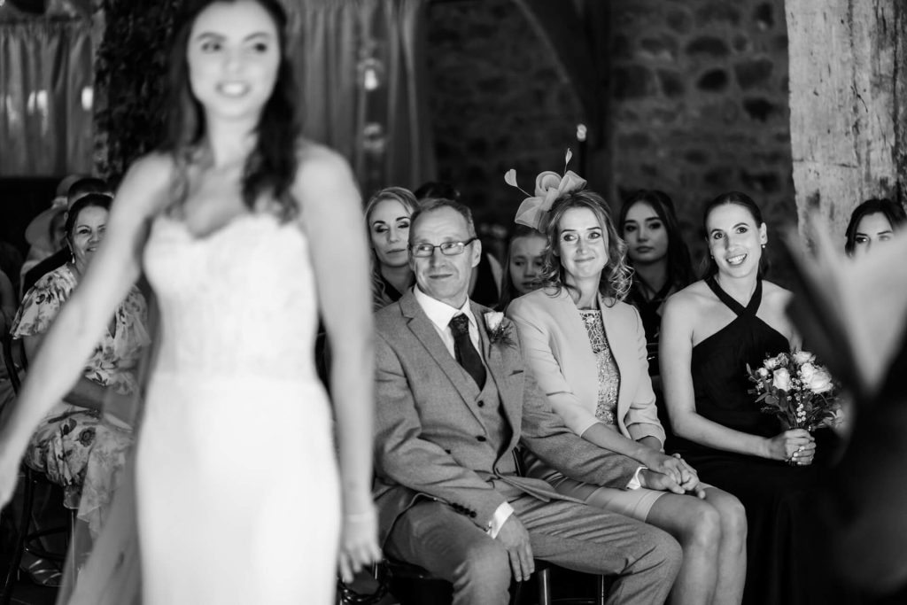 wedding guests smile and hold hands during the ceremony