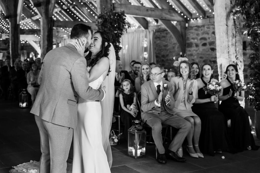 wedding couple have their first kiss in front of friends and family