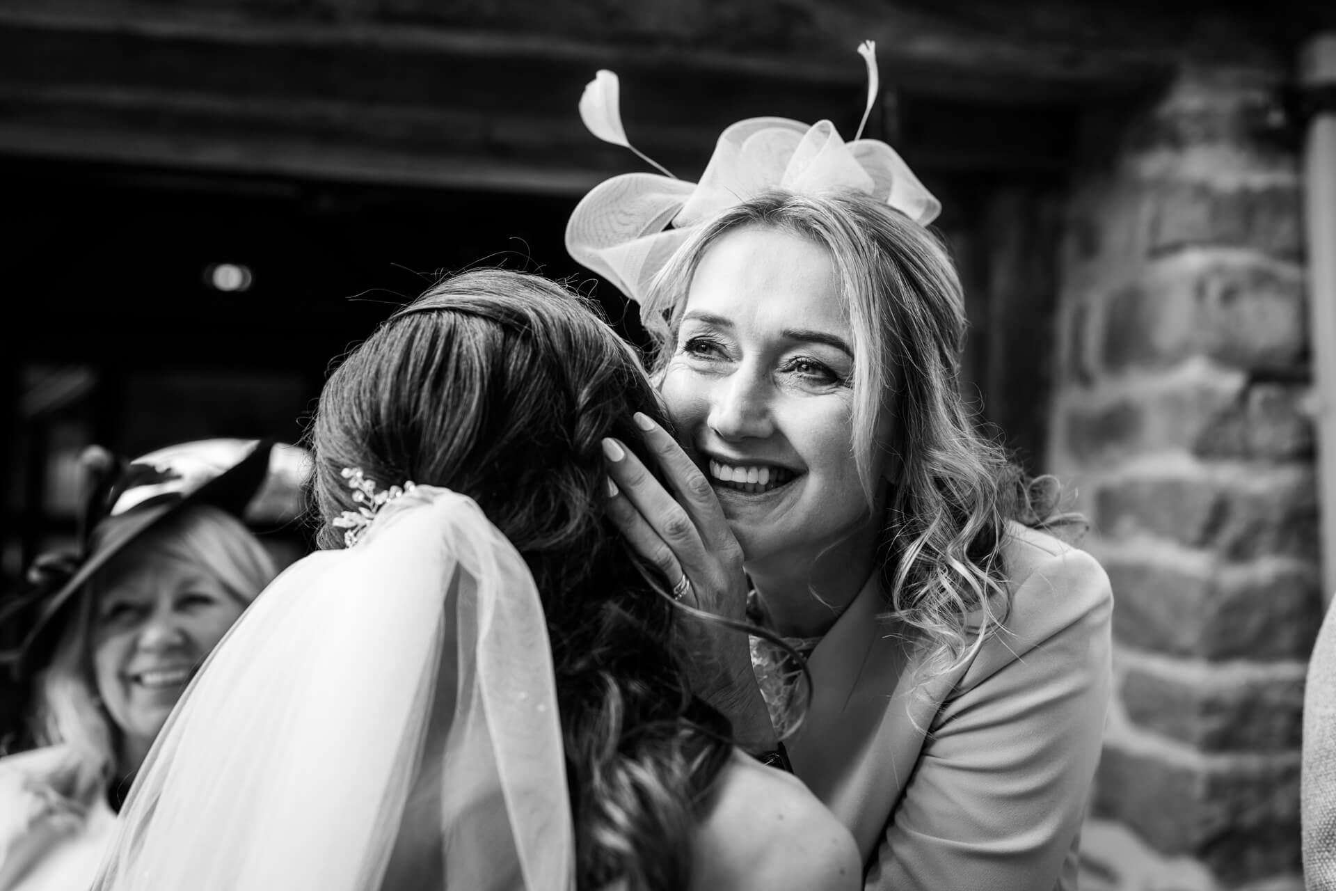 mother of the bride hugs her daughter