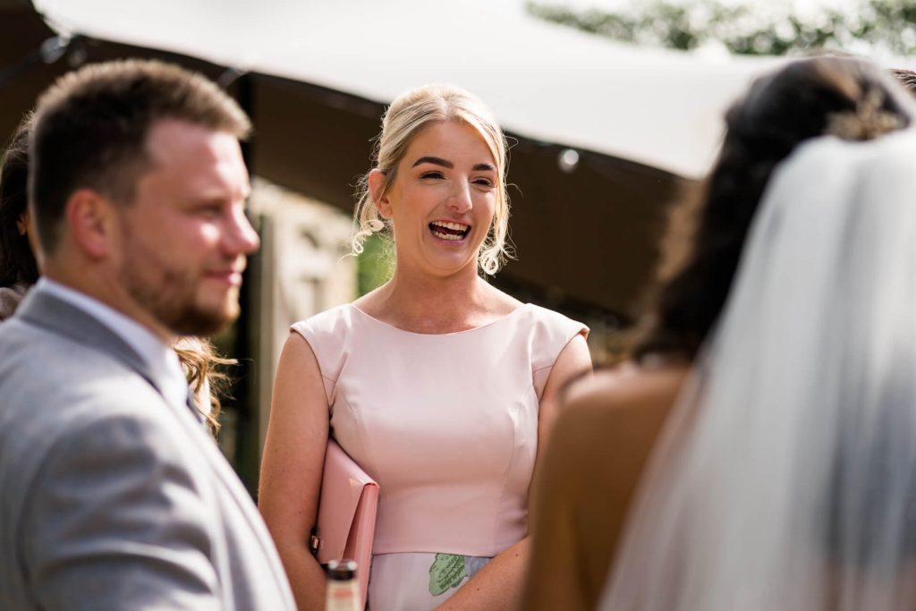wedding guests laugh with the bride
