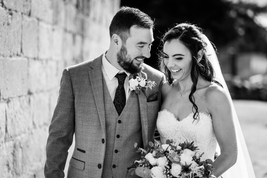 wedding couple walk together in the grounds of Bolton Abbey