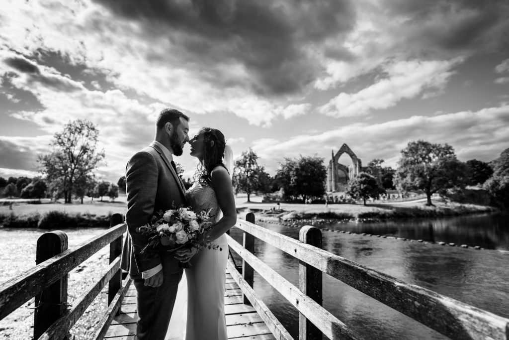 wedding couple kiss on a bride with Bolton Abbey in the background