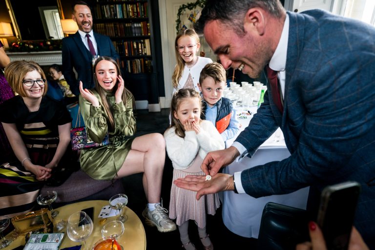 Magician performing trick for amazed audience.