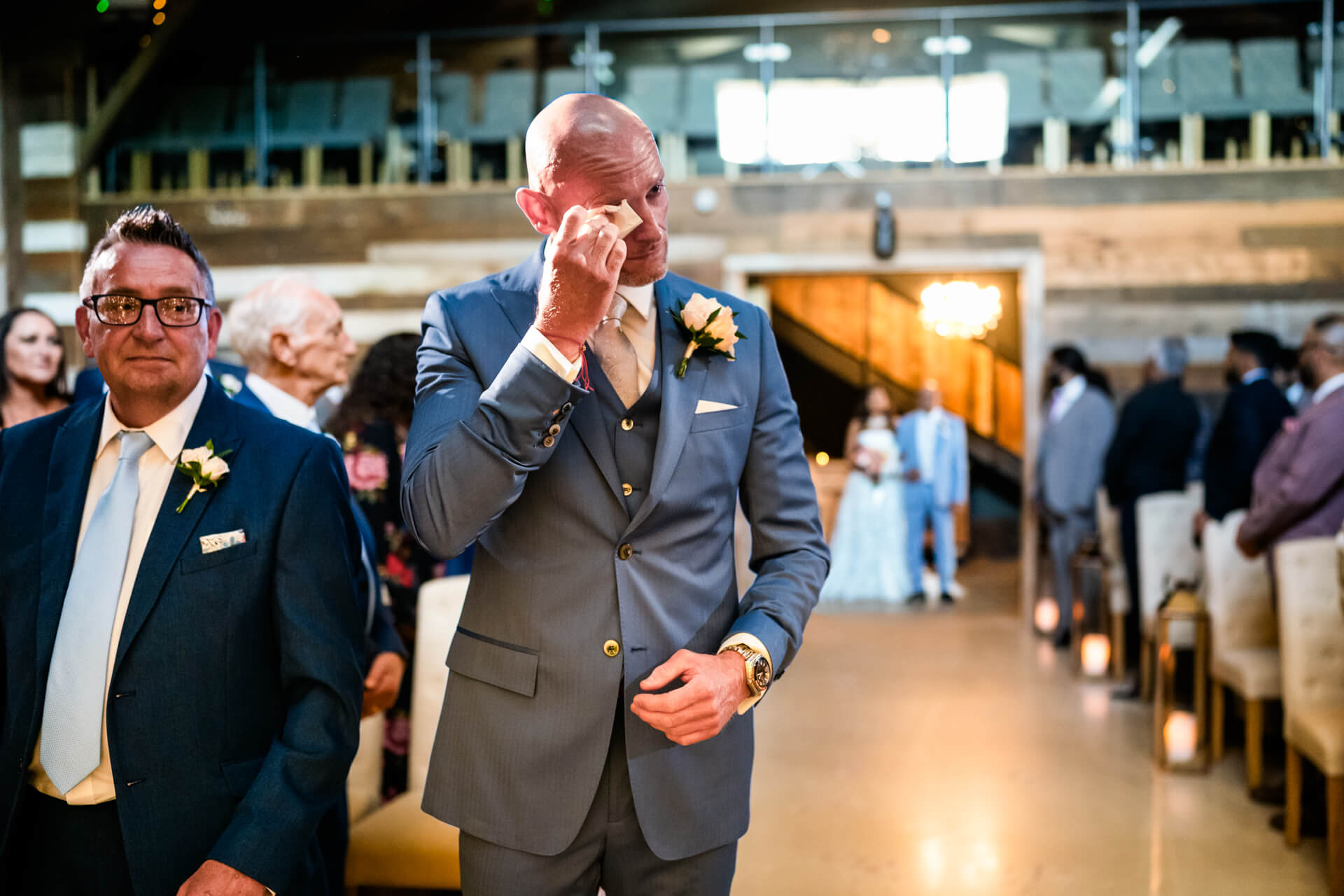 Emotional moment at wedding, man wiping tears.