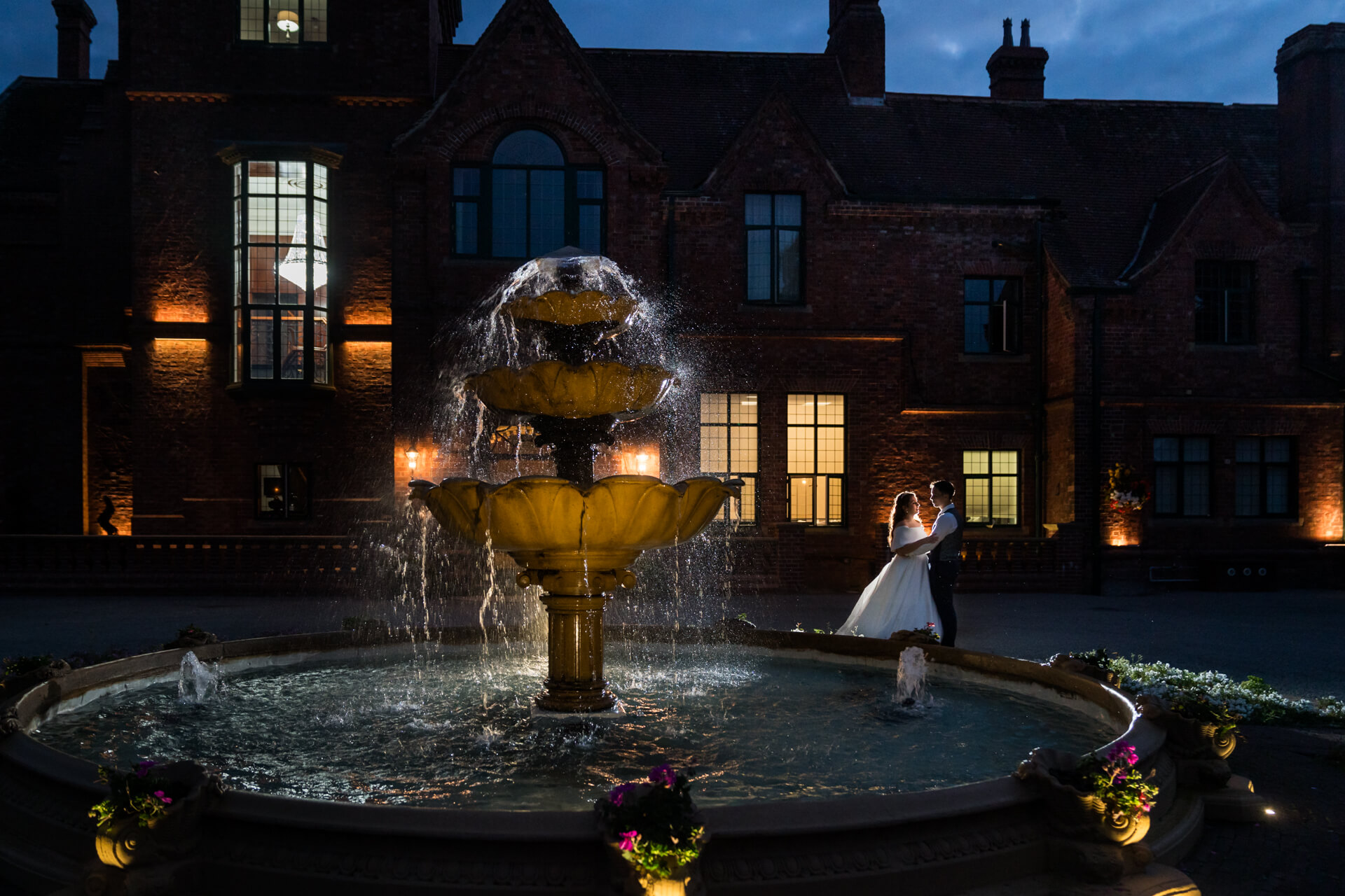 Couple dancing by fountain outside Aldwark Manor