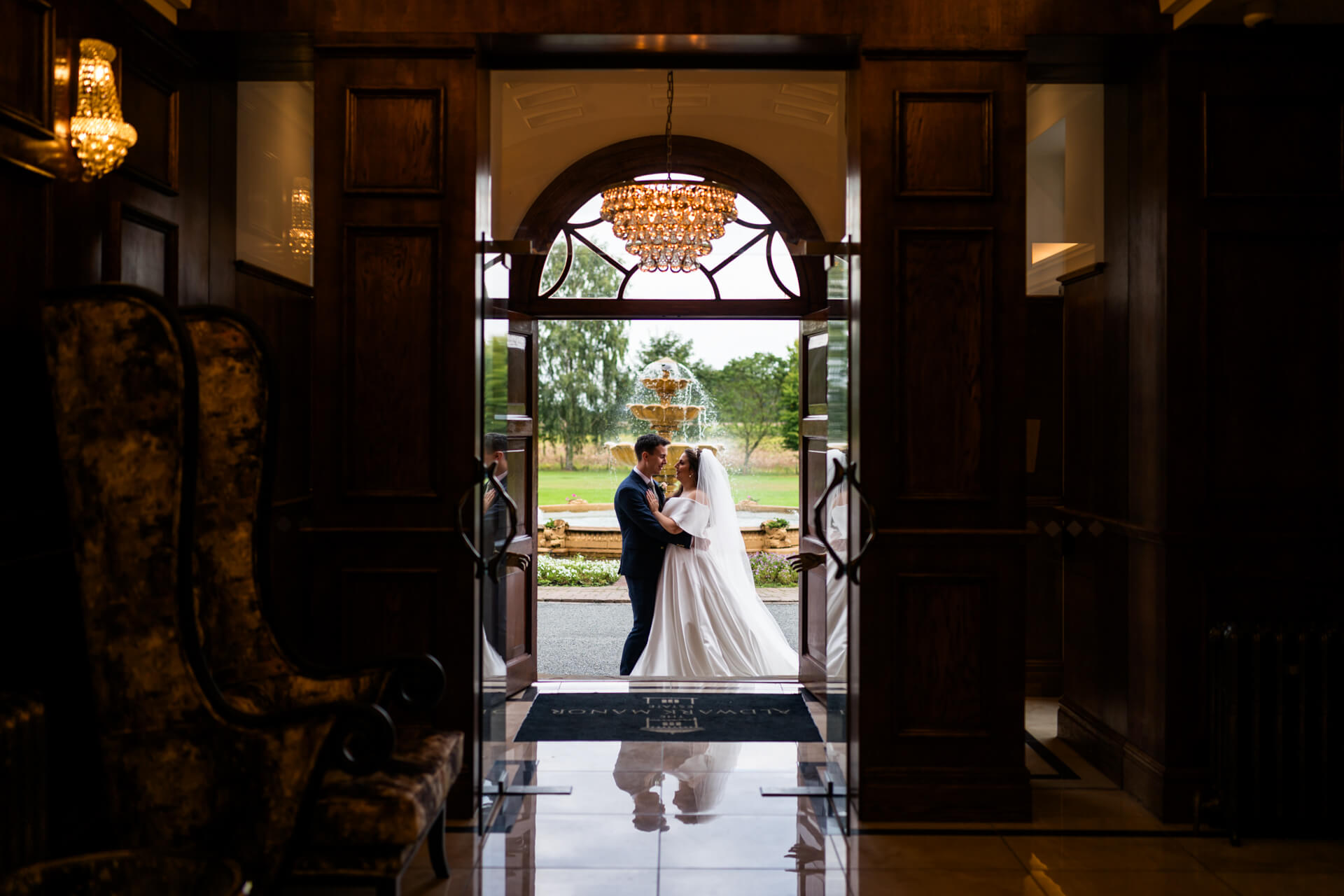 Couple embracing at elegant doorway during wedding.