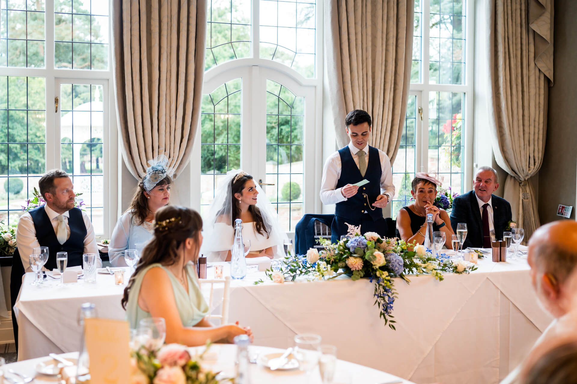 Groom giving speech at wedding reception.