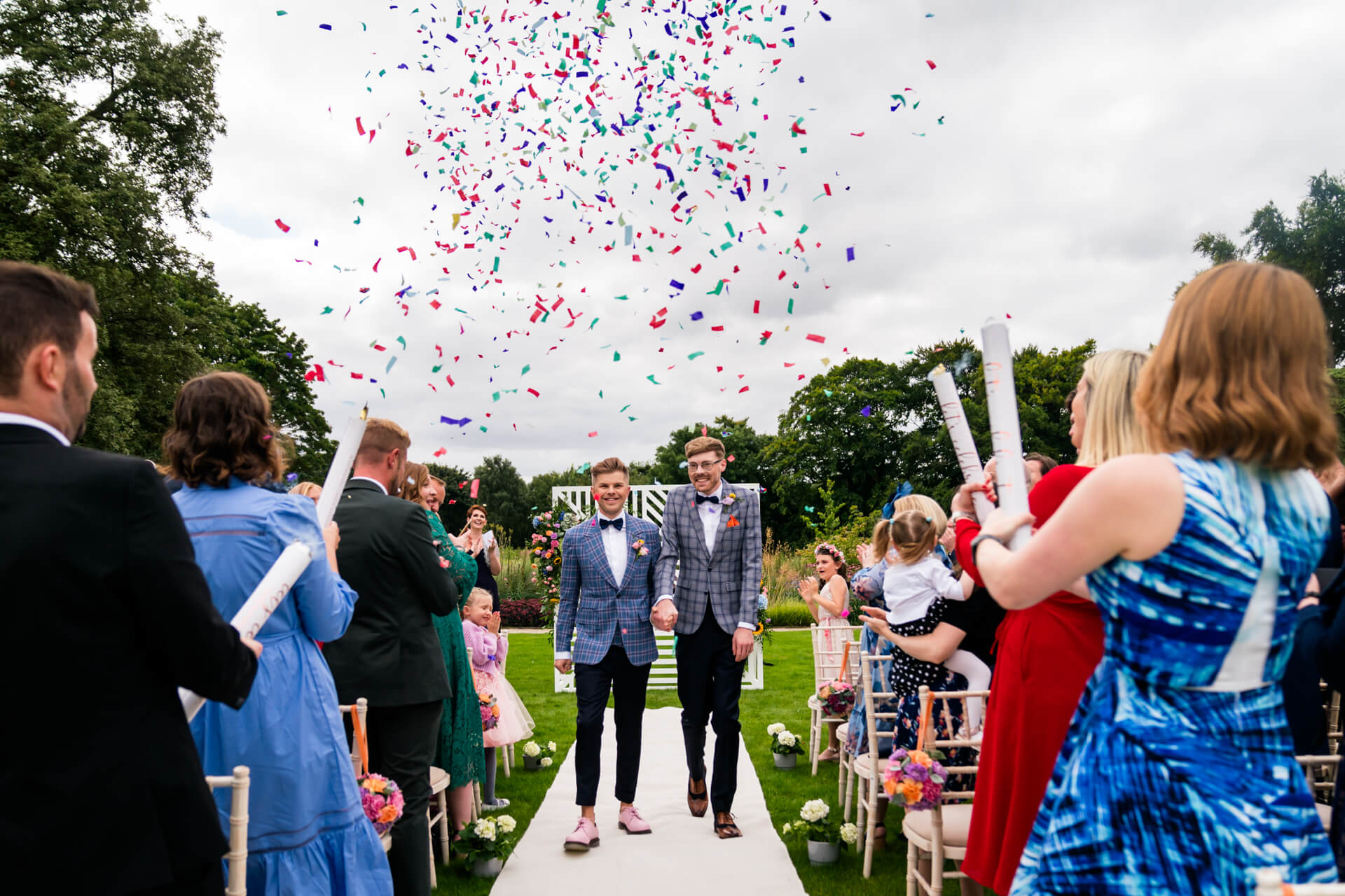 Couple walking under confetti at Bowcliffe Hall wedding celebration.
