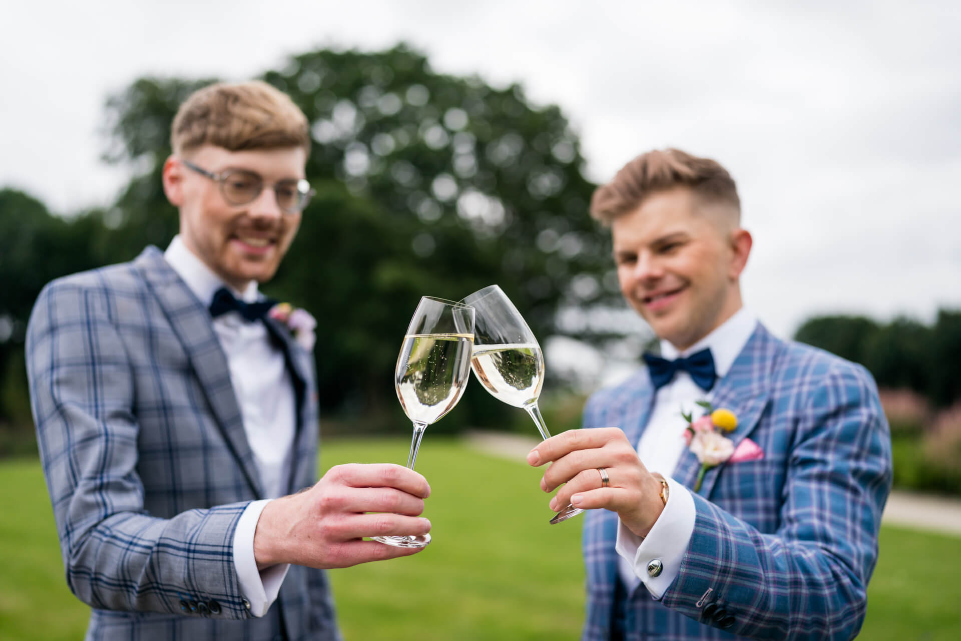 Two grooms toasting with champagne at their Bowcliffe Hall wedding