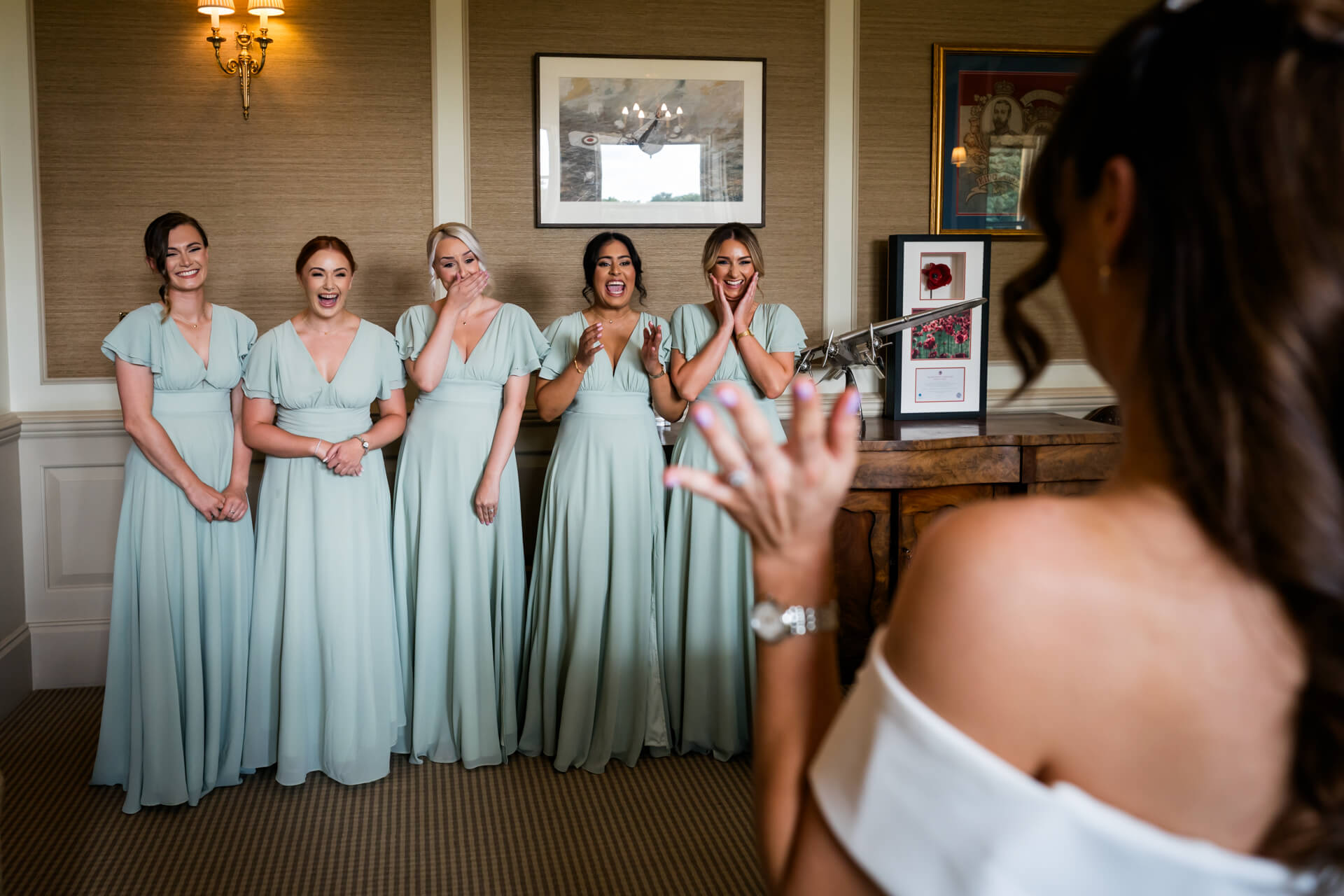 Bridesmaids in mint dresses admiring bride, joyful moment at Bowcliffe Hall
