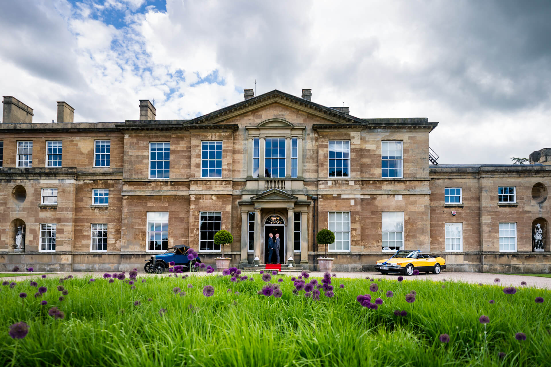 Bowcliffe Hall with vintage cars and blooming garden.