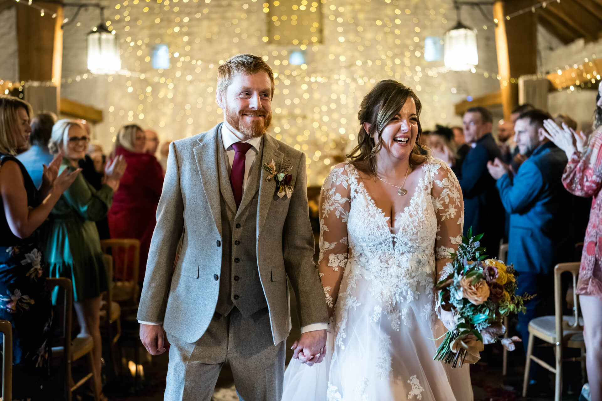 Bride and groom smiling, wedding celebration with guests.