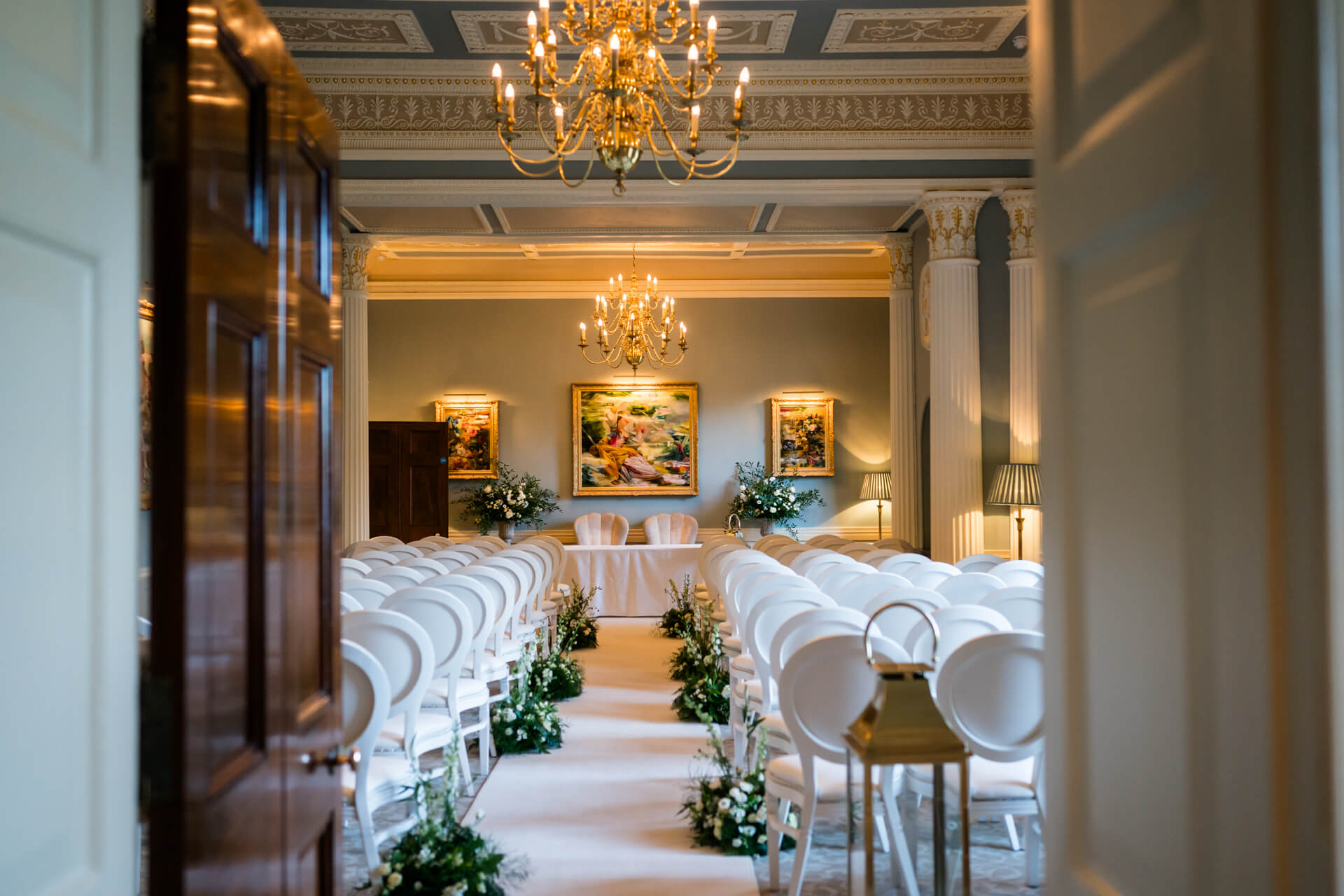 Grantley Hall ceremony room with chandeliers and flower decorations.