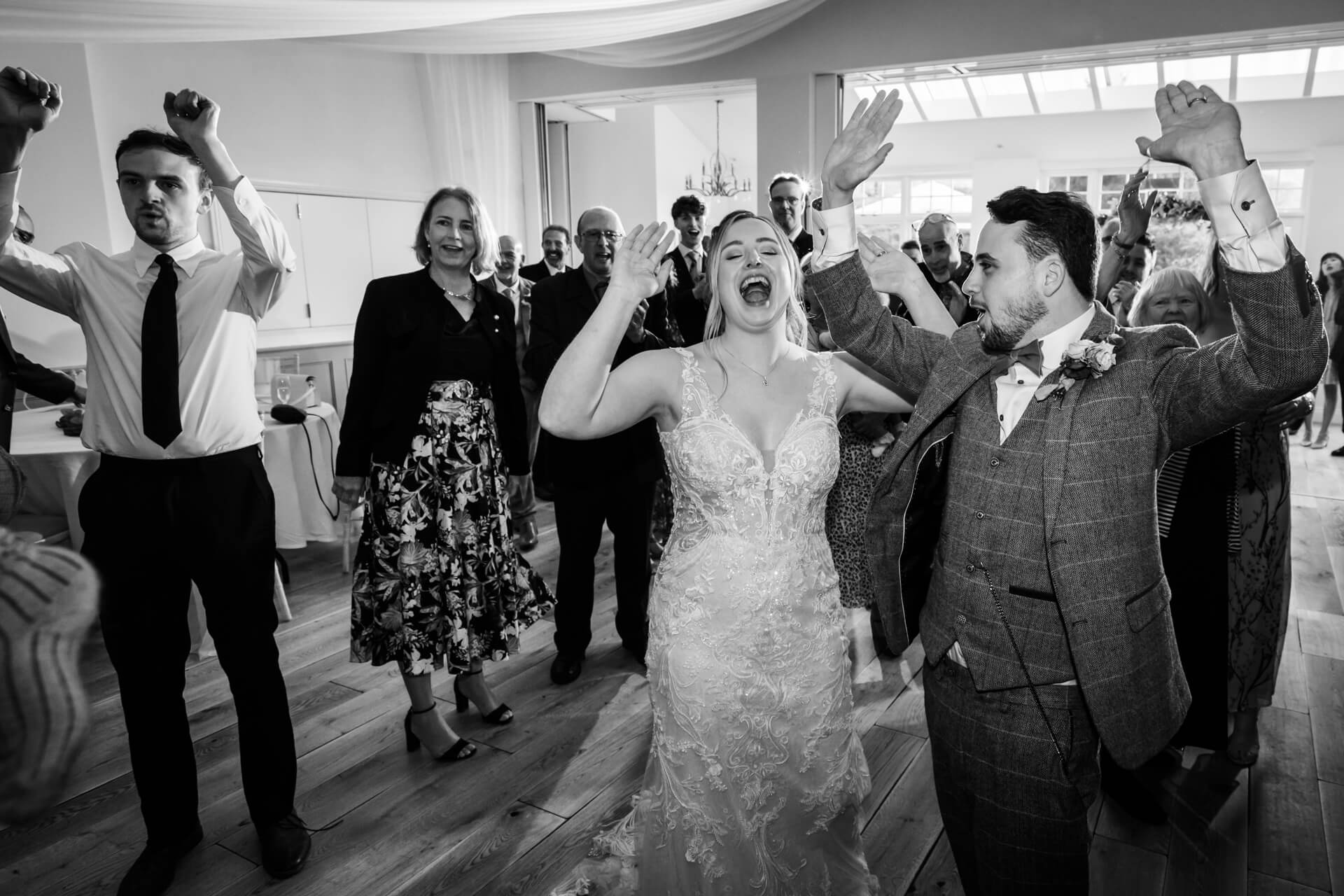Bride and groom celebrating with guests at wedding reception.