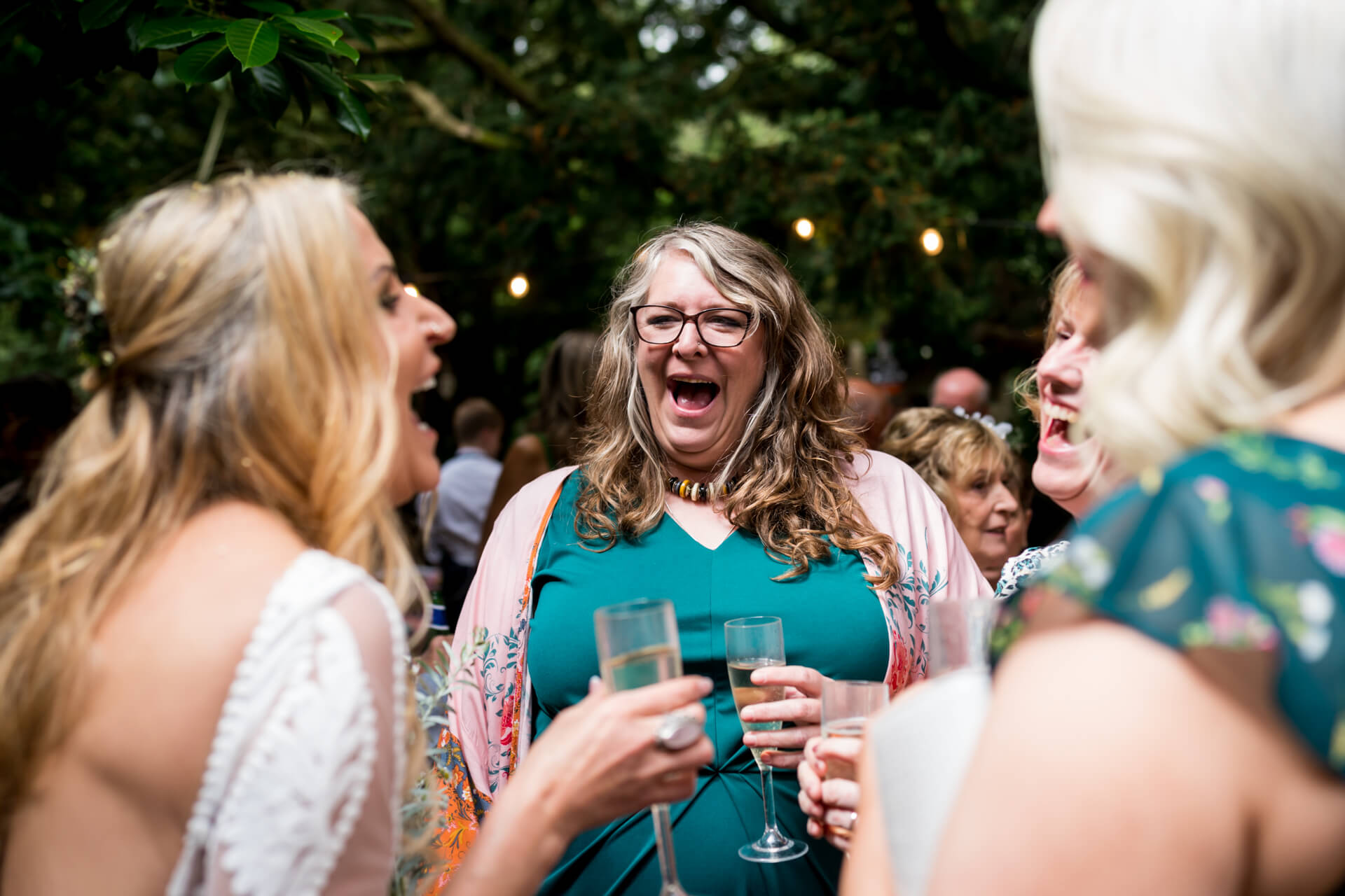 Women laughing with the bride at forest wedding