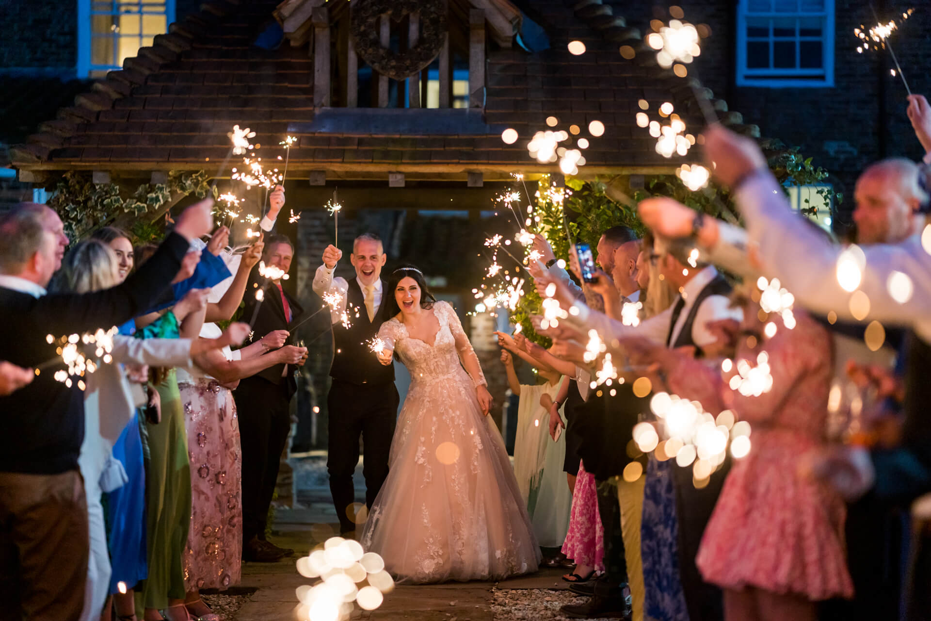 Bride and groom exiting with sparklers at evening reception at Hornington Manor